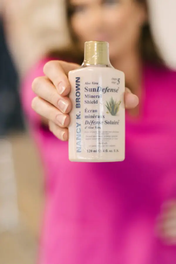 a person holding a bottle of sun protection.